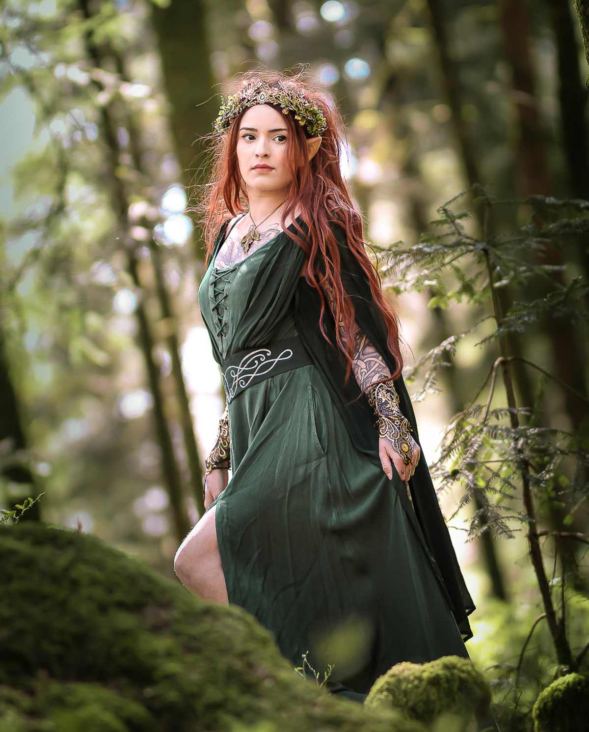 beautiful woman wearing a green renaissance dress in the woods