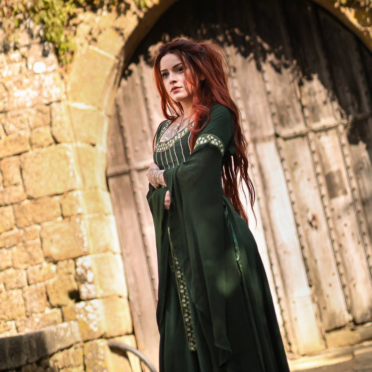 gorgeous woman with red hair wearing a green renaissance dress