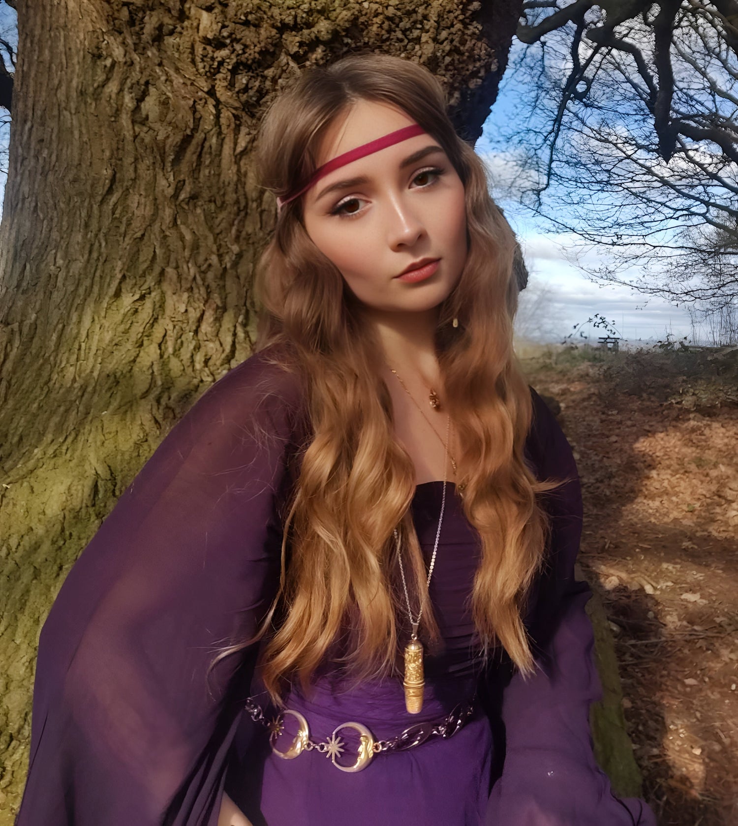 beautiful woman wearing an elegant dress leaning on a tree